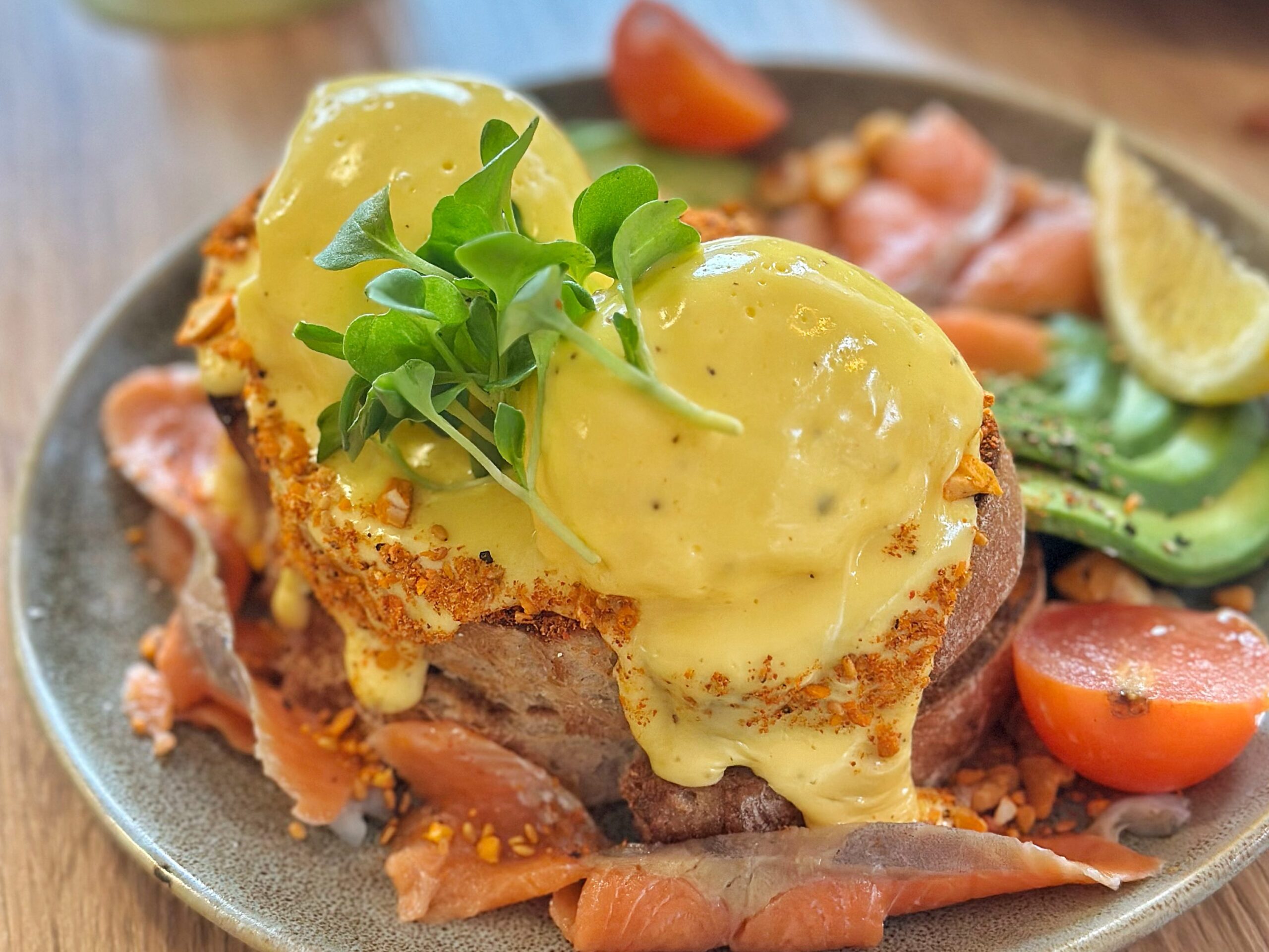 홀란다이즈 소스가 뿌려진 연어 아보카도 베네딕트